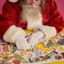 Person in Santa Claus costume working on a puzzle with a colorful design