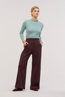 A woman wearing a striped blue top with brown wide-leg ribbed pants with an elastic waist.
