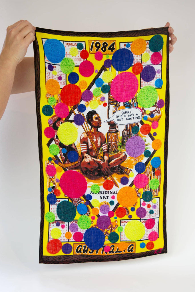 Colorful tea towel with art by Kait James, featuring colourful dots and Aboriginal person saying "Sorry, this is not a dot painting"